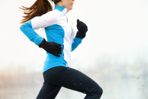 A young woman runs through cold weather